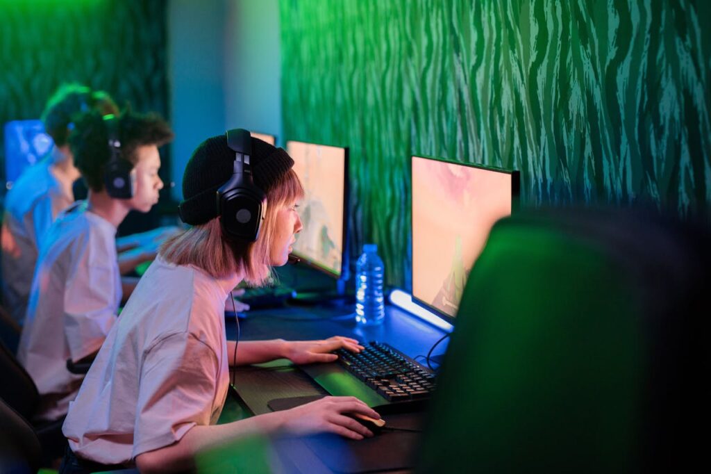 pexels-photo-7849510 Gamers intensely focused on playing in a vibrant cybercafe environment.